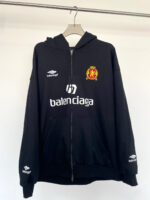 Felpa nera Balenciaga con logo sportivo Umbro e stemma regale, stile casual e di tendenza.