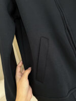 Felpa nera con tasca frontale, tessuto morbido e stile minimalista casual.
