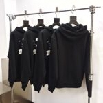 Esposizione di felpe nere minimaliste in negozio di moda contemporanea.