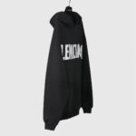 Felpa nera Balenciaga oversize con logo bianco, stile streetwear casual e di lusso.