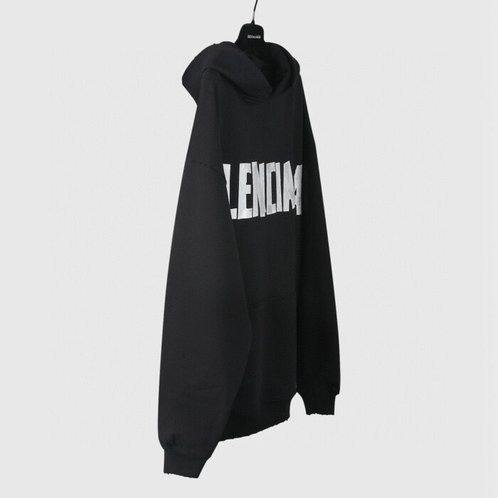 Felpa nera Balenciaga oversize con logo bianco, stile streetwear casual e di lusso.