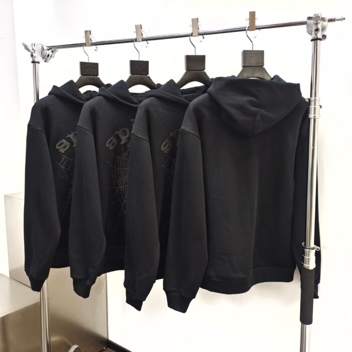 Esposizione di felpe nere semplici su rastrelliera moderna, stile minimalista ed elegante.