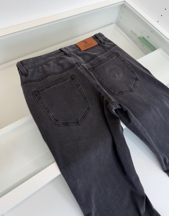 Jeans grigi moderni con tasche classiche e patch in pelle, stile casual e versatile.