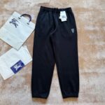 Pantaloni jogger neri casual con borse shopping e logo sulla coscia, stile sporty chic.