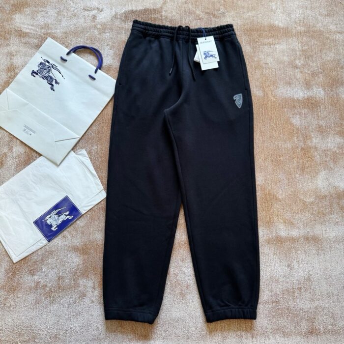 Pantaloni jogger neri casual con borse shopping e logo sulla coscia, stile sporty chic.