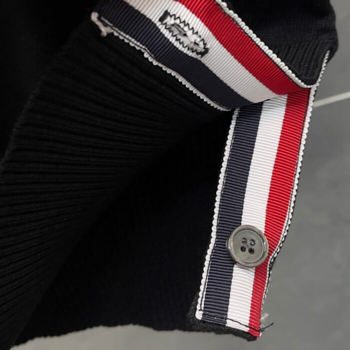 Polsino nero con strisce nautiche rosse, bianche e blu, dettagli di alta qualità e stile casual.