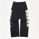 Pantaloni neri casual con dettagli a pizzo bianco e accenti rossi, stile urbano e confortevole.