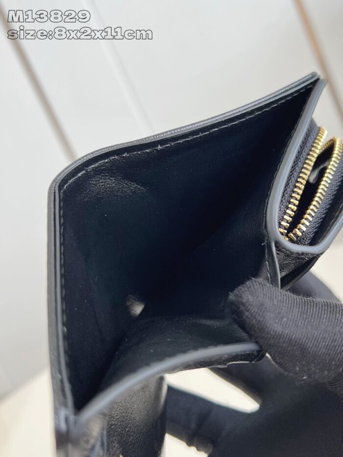 Portafoglio nero in pelle con interno minimalista e chiusura a zip con dettaglio dorato.