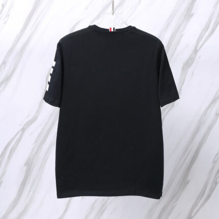 Maglietta nera minimalista con dettagli bianchi su manica, stile casual e versatile.