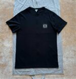 Maglietta nera con logo geometrico minimalista, stile casual e affidabile, perfetta per ogni occasione.