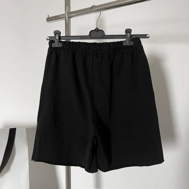 Pantaloncini neri minimalisti su gruccia, comfort e stile casual ideali per lestate.