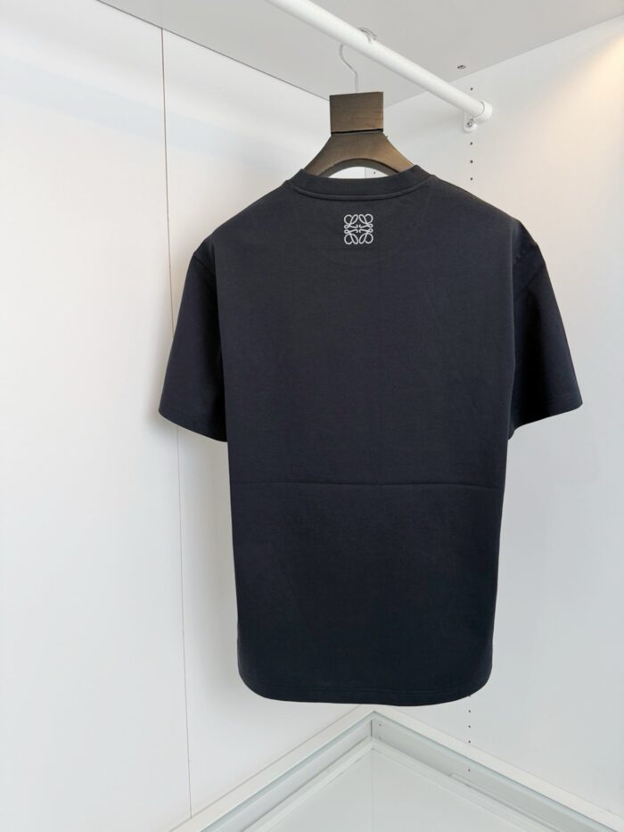 Maglietta nera minimalista con piccolo logo sul retro, stile casual e versatile.
