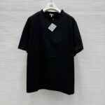 T-shirt nera minimalista in cotone su appendiabiti, versatile e moderna per ogni occasione.