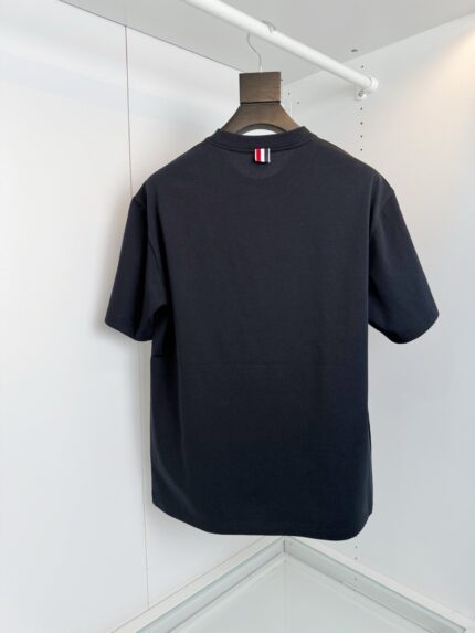 T-shirt nera elegante con dettaglio a strisce rosso-bianco-blu, stile minimalista e versatile.
