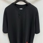 T-shirt nera minimalista con logo a fiamma colorato, stile streetwear casual e moderno.