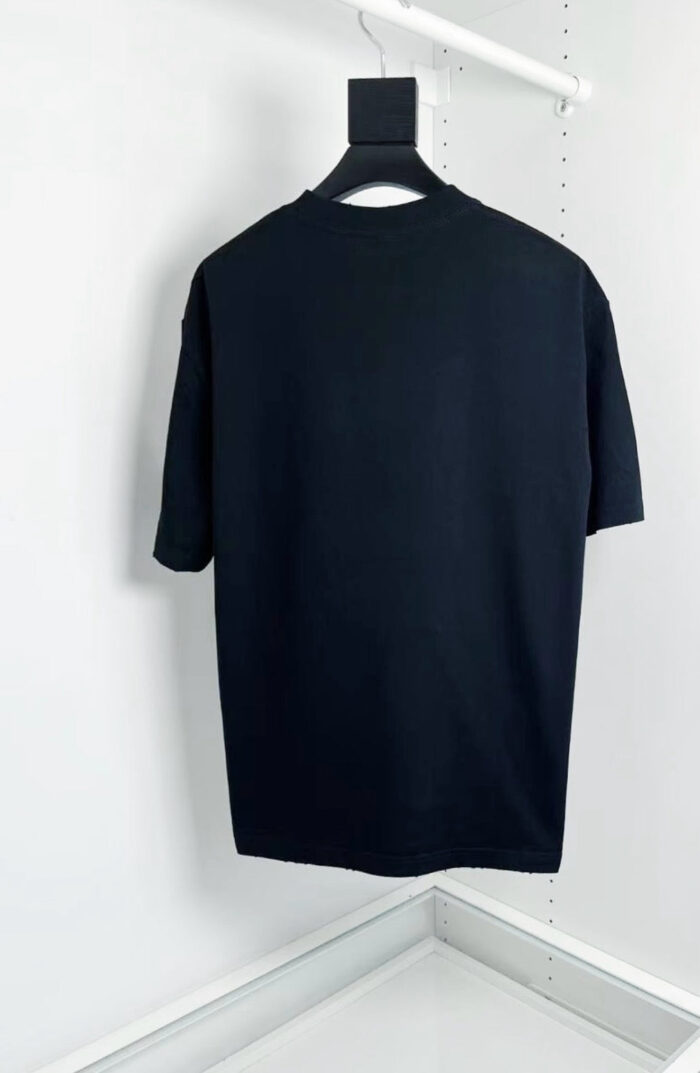 Maglietta nera oversize minimalista su appeso, stile moderno e versatile per ogni occasione.
