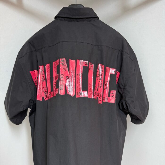 Giacca nera oversize con logo rosa stile Balenciaga, streetwear moderno e di tendenza.
