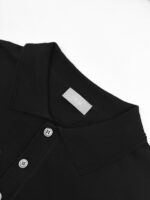 Maglietta polo nera elegante con colletto, bottoni e etichetta minimalista in stile classico.
