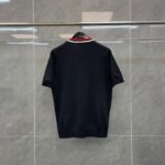Camicia polo nera con colletto rosso, stile elegante e versatile, ideale per ogni occasione.