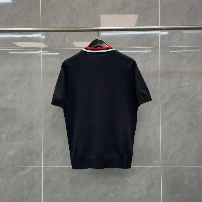 Camicia polo nera con colletto rosso, stile elegante e versatile, ideale per ogni occasione.