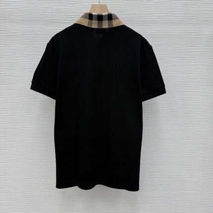 Maglietta polo nera con colletto a quadri beige e bianco, stile casual elegante.