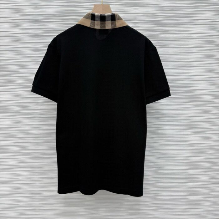 Maglietta polo nera con colletto a quadri beige e bianco, stile casual elegante.