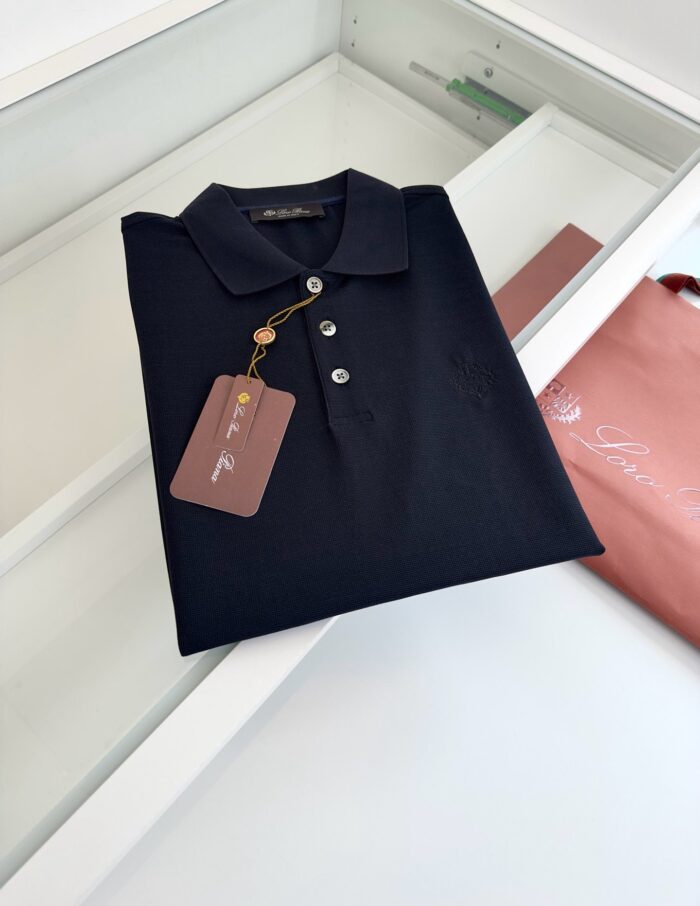 Maglietta polo nera elegante con etichetta e dettagli di stile sofisticato.