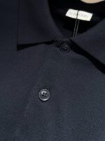 Maglietta polo blu navy di alta qualità con bottoni lucidi e colletto classico elegante.