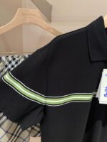 Maglietta polo nera con strisce verdi e dettagli moderni su appendiabiti di legno.