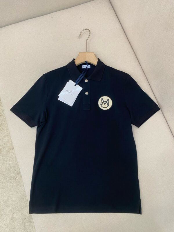 Maglietta polo nera elegante con logo circolare, in cotone di alta qualità, ideale per uno stile raffinato.