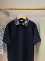 Maglietta polo nera con colletto tartan beige e marrone, stile elegante e versatile.