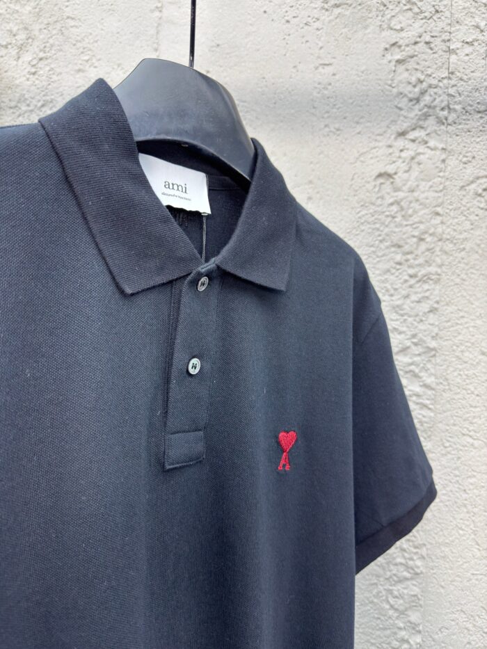 Maglietta polo nera con cuore rosso ricamato, stile casual ed elegante, perfetta per ogni occasione.