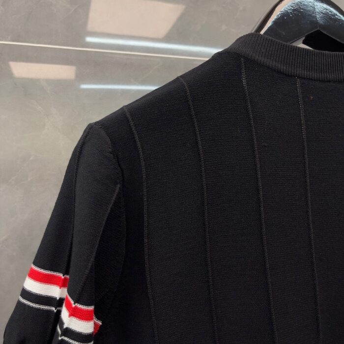 Maglione nero con righe colorate, stile casual e dettaglio a costine, adatto a ogni occasione.