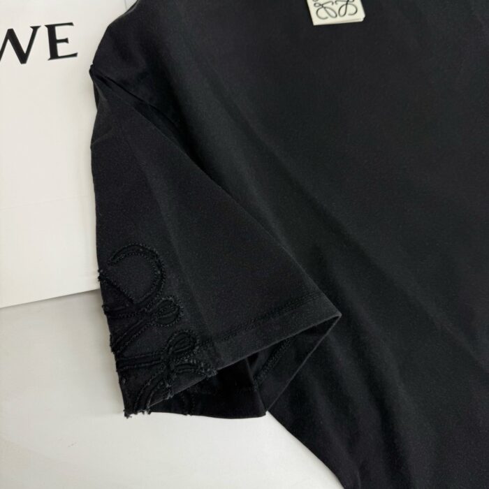 Camicia nera con ricamo elegante sulla manica e logo sottile, stile casual raffinato.