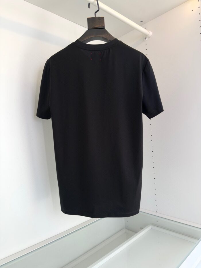 Maglietta nera minimalista a maniche corte, versatile e chic, su sfondo bianco con gruccia nero opaca.