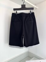 Pantaloncini neri eleganti con tasche, cinturino elasticizzato e risvolti grigi, stile moderno e versatile.