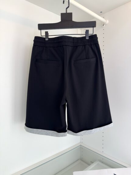 Pantaloncini neri eleganti con tasche, cinturino elasticizzato e risvolti grigi, stile moderno e versatile.