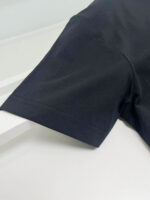Manica nera in tessuto minimalista e elegante, perfetta per uno stile versatile e moderno.