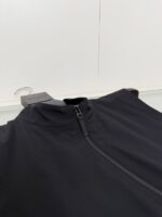 Giacca sportiva nera con zip, collo alto, ideale per attività e look casual.