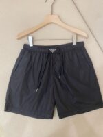 Pantaloncini neri sportivi con logo, elasticità, cordino regolabile e tessuto leggero.