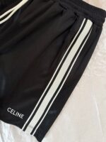 Shorts sportivi neri con strisce bianche e logo Céline, eleganti e di alta moda.
