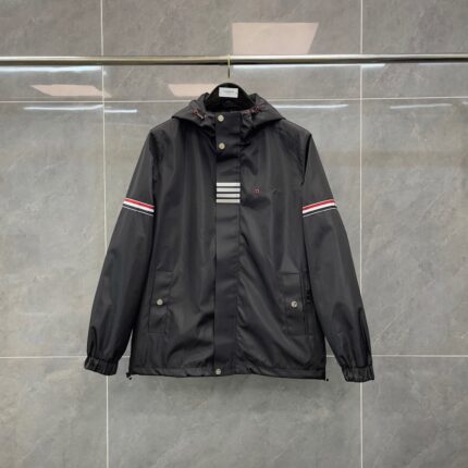 Giacca sportiva nera con cappuccio, strisce orizzontali e dettagli rossi, ideale per outdoor e stile casual.