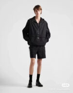 Stile urbano moderno con giacca oversize, shorts neri e stivaletti neri.