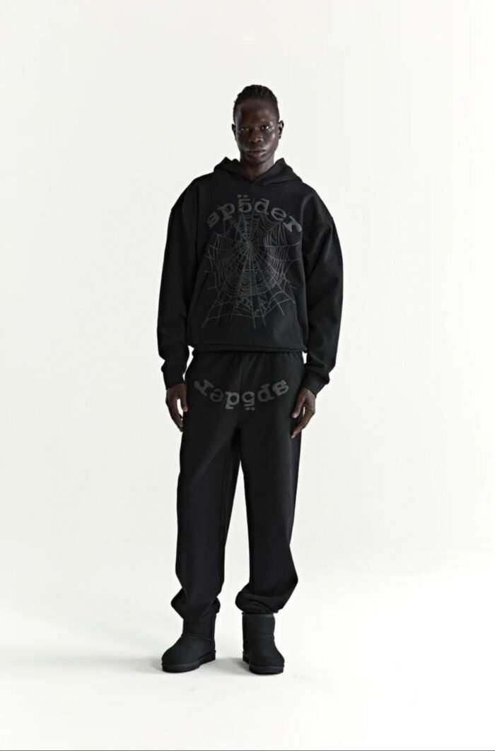 Look streetwear nero con hoodie oversized, joggers e stivali per uno stile urbano e moderno.