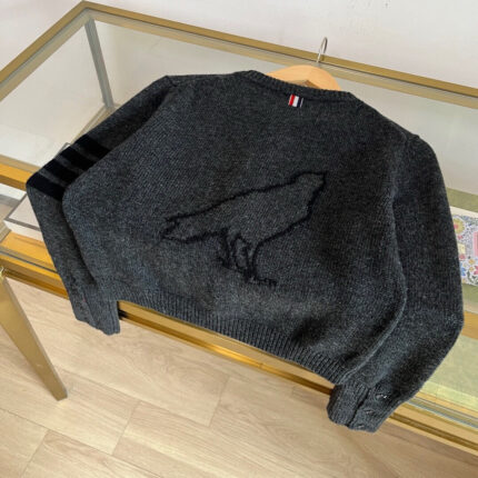 Maglione nero con ricamo di corvo, strisce sportive e dettaglio con bandiera, stile moderno e caldo.