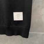 Maglia nera con profilo moderno e etichetta di cura visibile sul bordo.