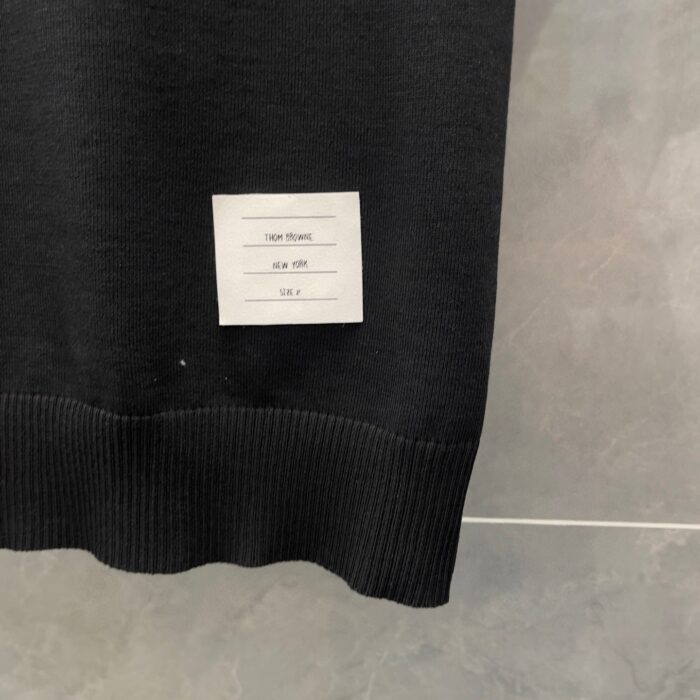 Maglia nera con profilo moderno e etichetta di cura visibile sul bordo.