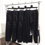 Jogger neri con dettagli forati e grafica, stile urbano e comfort moderno.