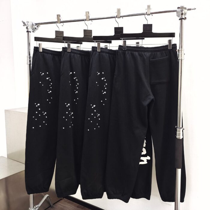 Jogger neri con dettagli forati e grafica, stile urbano e comfort moderno.