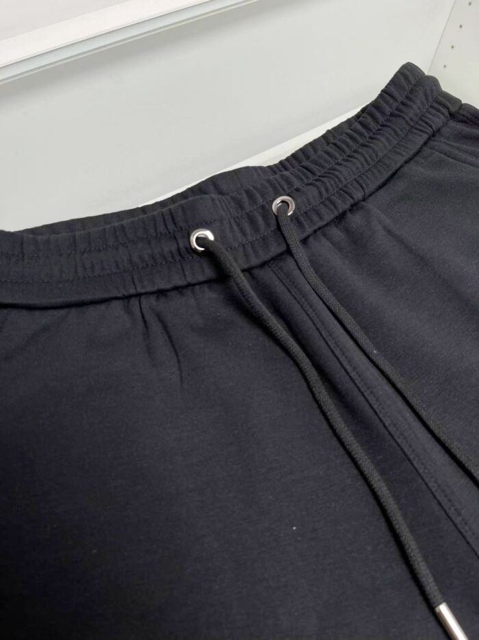Pantaloni felpati neri con cintura elastica e corda regolabile per sport e comfort quotidiano.